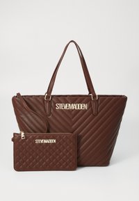 Rudos spalvos pintas nešiojamas krepšys su aukso detalėmis ir "STEVE MADDEN" logotipu. Rinkinį papildo atitinkamas užtrauktuku uždarytas maišelis su deimantų raštu ir auksine akcentu.