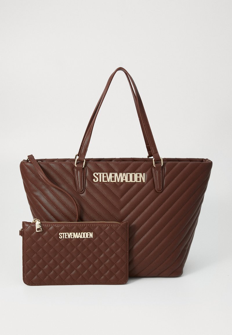 Sac fourre-tout matelassé marron avec quincaillerie dorée et logo "STEVE MADDEN". Comprend une pochette zippée assortie avec un motif en diamant et un accent doré.