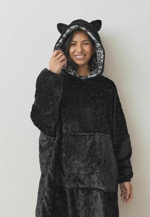 Musthave musto- ja leopardimustriga kapuutsiga oversized fliis, millel on voodriga kapuuts ja kassikõrvad ning ees tasku. Pehme ja mugav materjal.