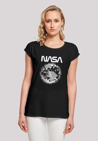 Schwarzes T-Shirt mit einem großen weißen "NASA"-Logo und einer Grafik der Erde, umgeben von zirkulärem Text. Kurze Ärmel und lockere Passform.