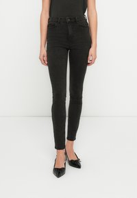 Sorte høytlivs skinny jeans med en jevn denimtekstur. Tettsittende design med frontlommer og klassisk knappelukking.