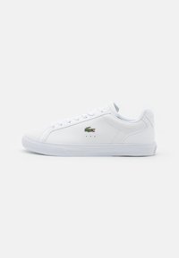 White leather sneaker with a low-cut design, flat sole, and lace-up front. Features a small green crocodile logo and subtle perforations.