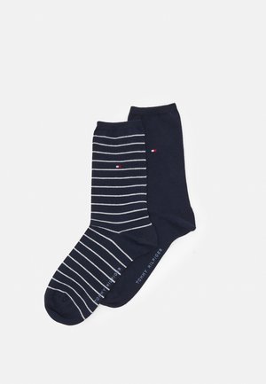 Navy cotton socks, one with white vertical stripes and a logo accent, the other a solid navy. Soft texture, crew length design.