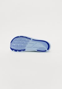 Semelle de chaussure avec une base bleu clair et des accents bleu foncé. Présente des motifs de crampons texturés pour traction et adhérence.