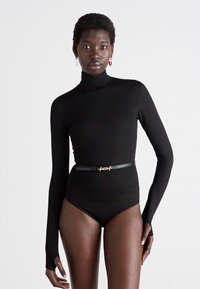 Zwart coltrui body met lange mouwen, slank hoog uitgesneden ontwerp, opgebonden met een dunne zwarte riem met een gouden accent. Glad oppervlak.