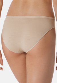 Mutande hipster beige con una texture a costine, cintura elastica e bordi senza cuciture. Leggera lucentezza con un taglio classico per il massimo comfort.