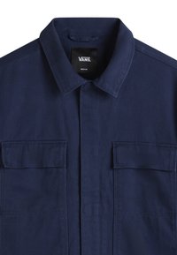 Navy blue, short-sleeve button-up shirt from Vans, made of woven fabric with a smooth texture, featuring two front pockets and a collar.