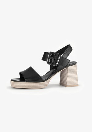 Black leather heeled sandals with a wide strap and a buckle. Features a chunky striped block heel and an open toe design.