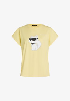 Maglietta gialla con al centro la stampa di un gatto bianco che indossa occhiali da sole neri e un collare, con il piccolo testo "Karl Lagerfeld" sopra il gatto.