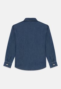 Mørkeblå denimskjorte med lange ermer, spiss krage og mansjetter med knapper. Har et rent, strukturert stoff uten mønstre.