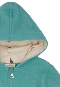 Felpa con cappuccio turchese in pile con cappuccio foderato, caratterizzata da un motivo di pecore su sfondo beige. Chiusura con zip dalle estremità arrotondate.