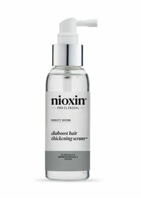Heldere glazen fles met een zilveren pomp, gelabeld "Nioxin Pro Clinical," bevat een transparante serum; heeft een wit en grijs ontwerp.