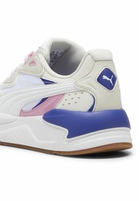 Białe sneakersy wykonane z siateczki i skóry, z fioletowymi i różowymi akcentami, teksturowanym obcasem oraz gumową podeszwą o charakterystycznym wzorze.