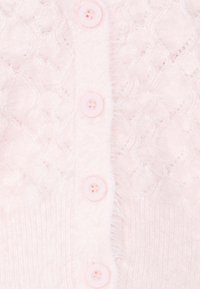 Ljusrosa cardigan med ett texturerat kabelstickat mönster och sex matchande knappar fram; mjukt, fluffigt material med fransiga kanter.