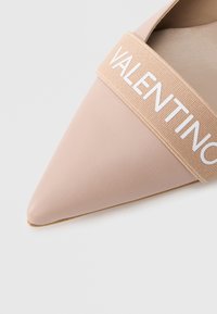 Nokksamet beeži nahast king, millel on lai elastne rihm, millel on valge "VALENTINO" tekst üleval.