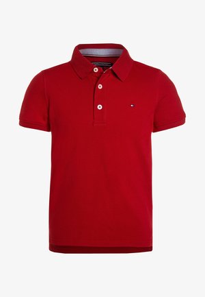Rød polo med korte ærmer med to hvide knapper på knappelåsen og lille Tommy Hilfiger flaglogo på venstre bryst.