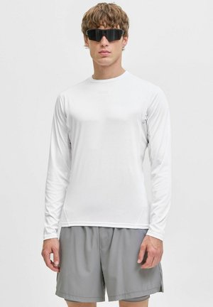 Weißes Langarmhemd mit glatter Textur, kombiniert mit grauen Shorts. Das Model trägt schwarze Sonnenbrillen. Einfaches, sportliches Design, ohne Muster.