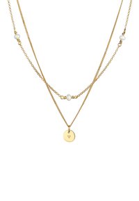Goldfarbene, mehrschichtige Halskette mit zwei Ketten, von denen eine einen runden Metallanhänger und die andere asymmetrisch platzierte weiße Perlen hat.