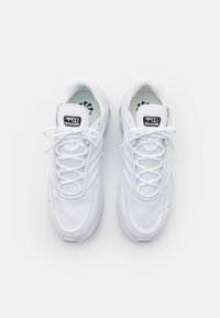 Scarpe atletiche bianche con tomaia in rete, design con lacci, suola ammortizzata e logo nero sulla linguetta. Dettagli testurizzati su tutta la superficie.