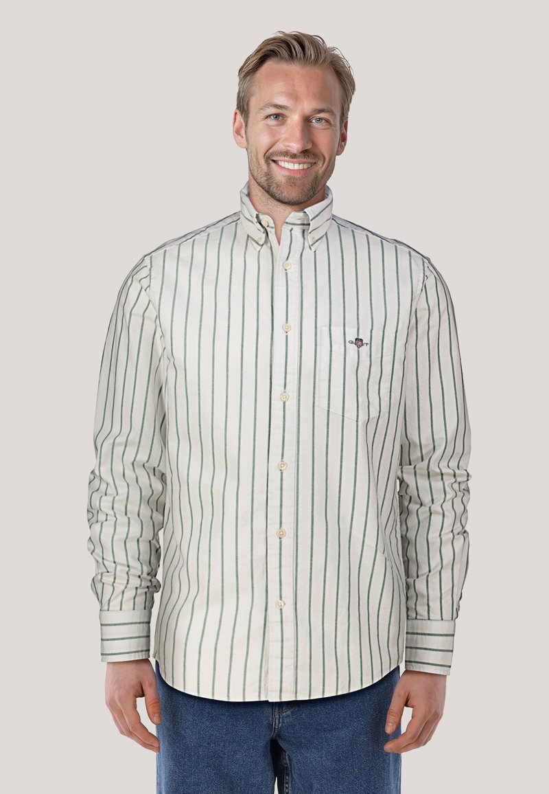 Witte button-down blouse met groene verticale strepen, lange mouwen en een borstzak. De textuur lijkt glad en de stof is lichtgewicht.