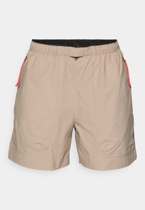 Beige shorts with an elastic waistband, red drawstring accents, and side pockets. Smooth fabric and tailored cut, suitable for casual wear.
