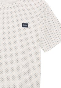 Kortærmet hvid t-shirt med lille sort og orange geometrisk mønster, med et marineblåt mærke på øverste venstre side.