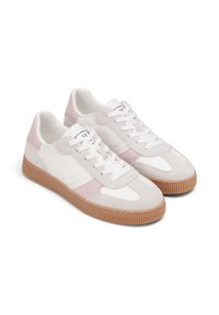 Weiße Sneaker mit pinken Wildlederakzenten und einer Gummisohle, die ein klassisches Design mit Schnürverschluss und durchbrochenen Details zeigen.