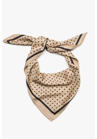 Jedwabny szal w beżowym kolorze z czarnymi kropkami, z kontrastową czarną obwódką. Skręcony i złożony w trójkątny kształt.