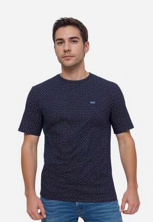 Marineblaue T-Shirt mit kleinem Logo, das ein geometrisches Punktmuster in Rot und Weiß zeigt. Kurze Ärmel und Rundhalsausschnitt, aus Baumwolle gefertigt.