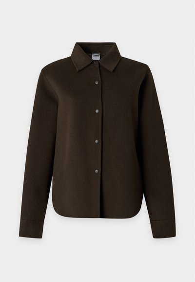 Veste-chemise manches longues marron foncé avec col classique et boutons-pression devant sur un fond clair uni.