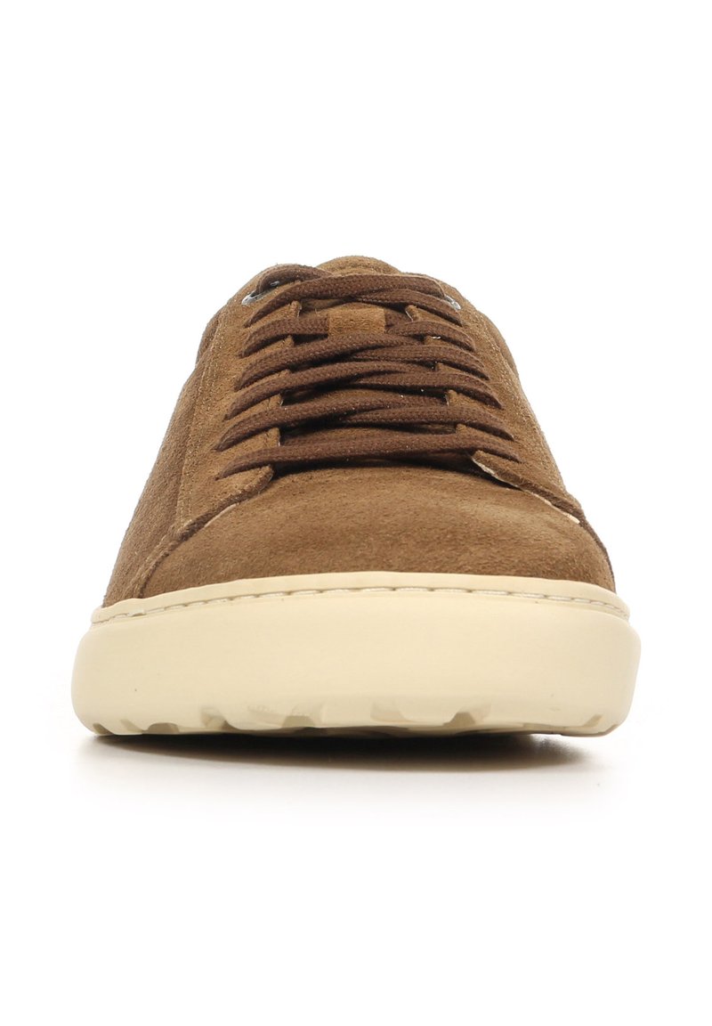 Brown suede sneaker with lace-up closure, rounded toe, and a cream-colored rubber sole featuring a textured tread.