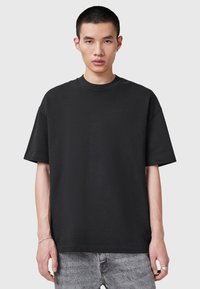 Czarny, oversize t-shirt z bawełny z krótkim rękawem, okrągłym dekoltem, z małym tłoczonym logo na piersi i luźnym krojem.