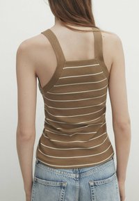 Débardeur rayé marron à coupe ajustée, avec larges bretelles et texture côtelée, assorti à un short en denim bleu clair taille haute.