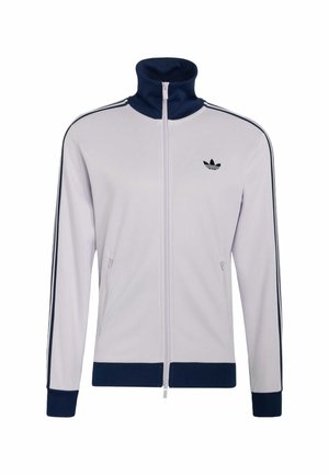 Veste blanche zippée avec col, poignets et ourlet bleu marine, ornée de rayures noires le long des manches et d'un logo Adidas noir sur la poitrine.