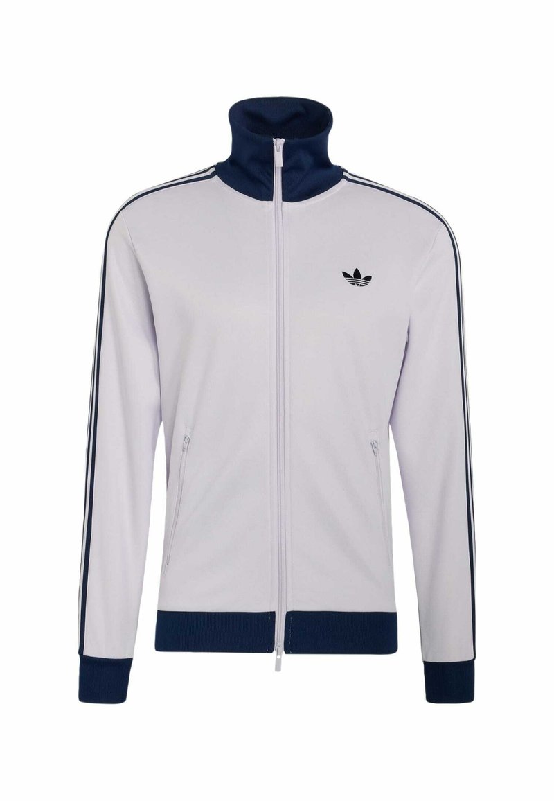 Chaqueta blanca con cremallera, con cuello, puños y dobladillo azul marino, con rayas negras a lo largo de las mangas y un logo negro de Adidas en el pecho.