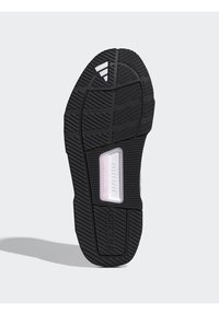 Μαύρη σόλα παπουτσιού από καουτσούκ με υφή πέλματος, με ένα κεντρικό λευκό ορθογώνιο διακοσμητικό με τις επιγραφές "REPETITOR" και "TRAXION".