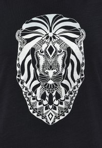 Czarny T-shirt z szczegółową grafiką białego lwa, złożoną z misternych wzorów i kształtów geometrycznych, podkreślającymi liniowość i symetrię.