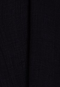 Czarna tkanina o teksturowanej powierzchni, z delikatnym wzorem splotu. Materiał wydaje się miękki i gładko układa się.