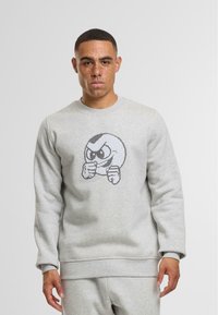 Felpa grigia chiara realizzata in cotone misto, con un design grafico di un personaggio dei cartoni animati con un'espressione arrabbiata sul davanti.