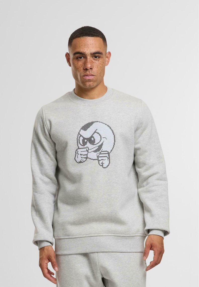 Felpa grigia chiara realizzata in cotone misto, con un design grafico di un personaggio dei cartoni animati con un'espressione arrabbiata sul davanti.