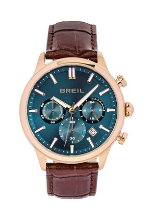 Orologio Breil con cassa in bronzo, quadrante verde acqua, tre sottocanali e visualizzazione della data. Cinturino in pelle marrone con finitura testurizzata e dettagli di cucitura.