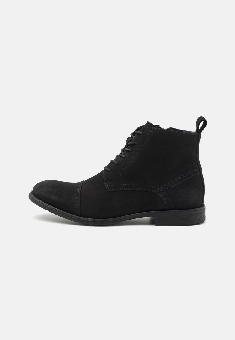 Bottine en daim noir avec lacets à l'avant, fermeture éclair latérale, petit talon et languette à tirer sur fond blanc.