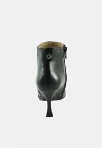 Stivale alla caviglia in pelle nera con un design elegante, punta appuntita, tacco alto, zip laterale e un bottone decorativo sul retro.