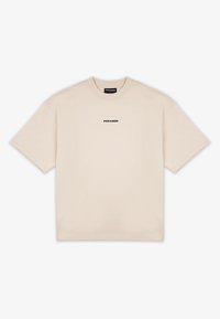 Vaaleanbeige lyhythihainen crewneck-t-paita, jossa on pieni musta "PEGADOR" -logo keskitettynä rinnassa ja kaulustunnuksessa.