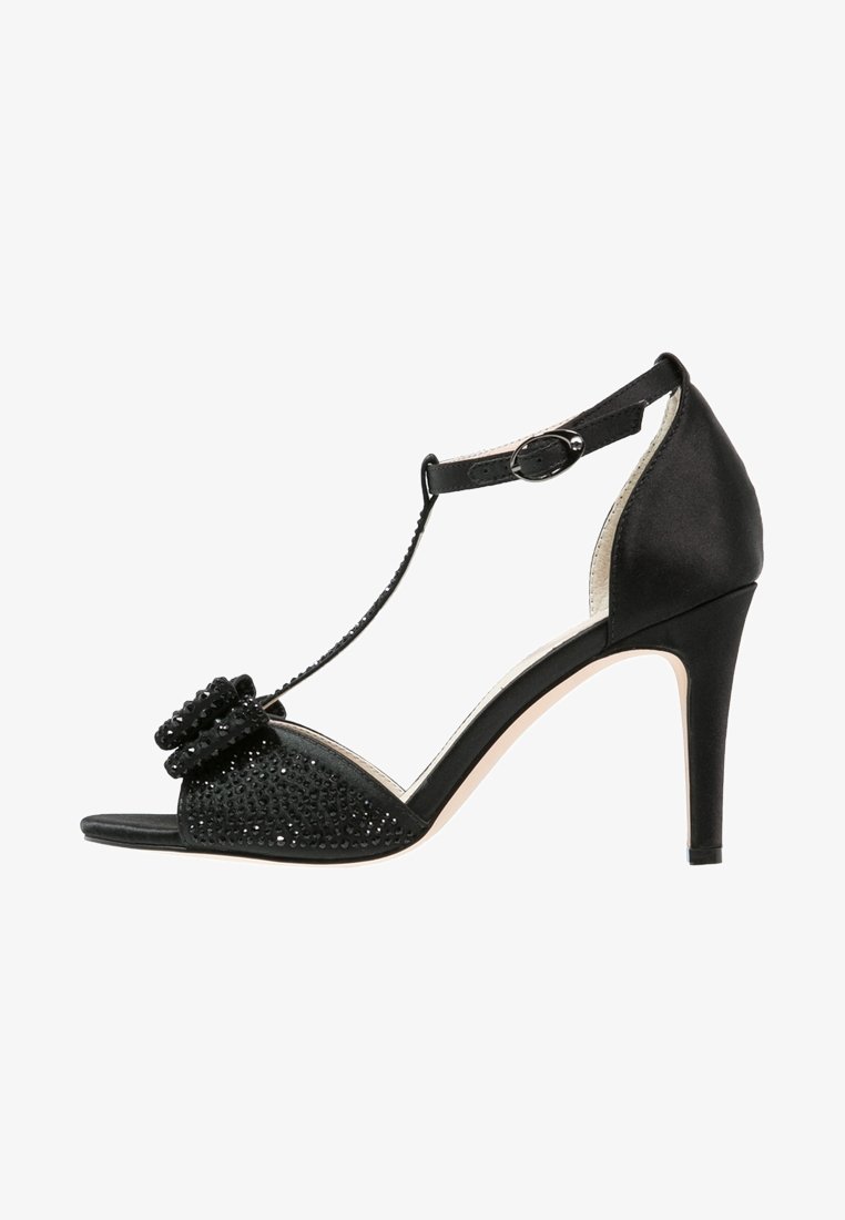 Sandale noire à talon haut avec bride à la cheville, bout ouvert orné et nœud décoratif avec petites pierres scintillantes.