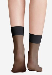 Przezroczyste brązowe skarpety z czarną gumką na górze, prezentujące gładką teksturę i dopasowany krój.