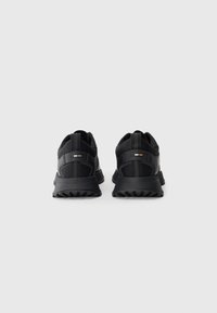 Pantofi sport negri cu un upper din plasă, talpă amortizată și accente texturate. Designul include un detaliu mic aurit pe călcâi.