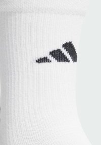Weißer Sportsocke mit schwarzem Drei-Streifen-Logo am Bündchen, gerippter Textur für Komfort und leicht dehnbarem Material.