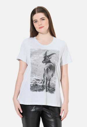 Camiseta gris claro con un gráfico en blanco y negro de una cabra de espaldas, con mangas cortas y cuello redondo.