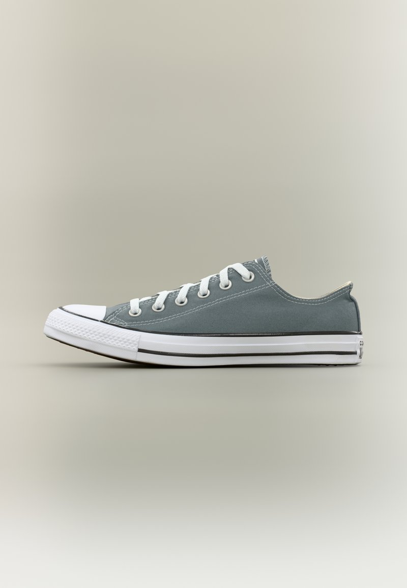 Γκρι πάνινο αθλητικό παπούτσι με χα μηλό σχεδιασμό, λευκή ελαστική μύτη και λευκά κορδόνια. Διαθέτει μαύρη ρίγα κατά μήκος της σόλας.